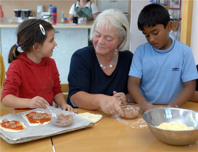 eine Frau und zwei Kinder backen zusammen